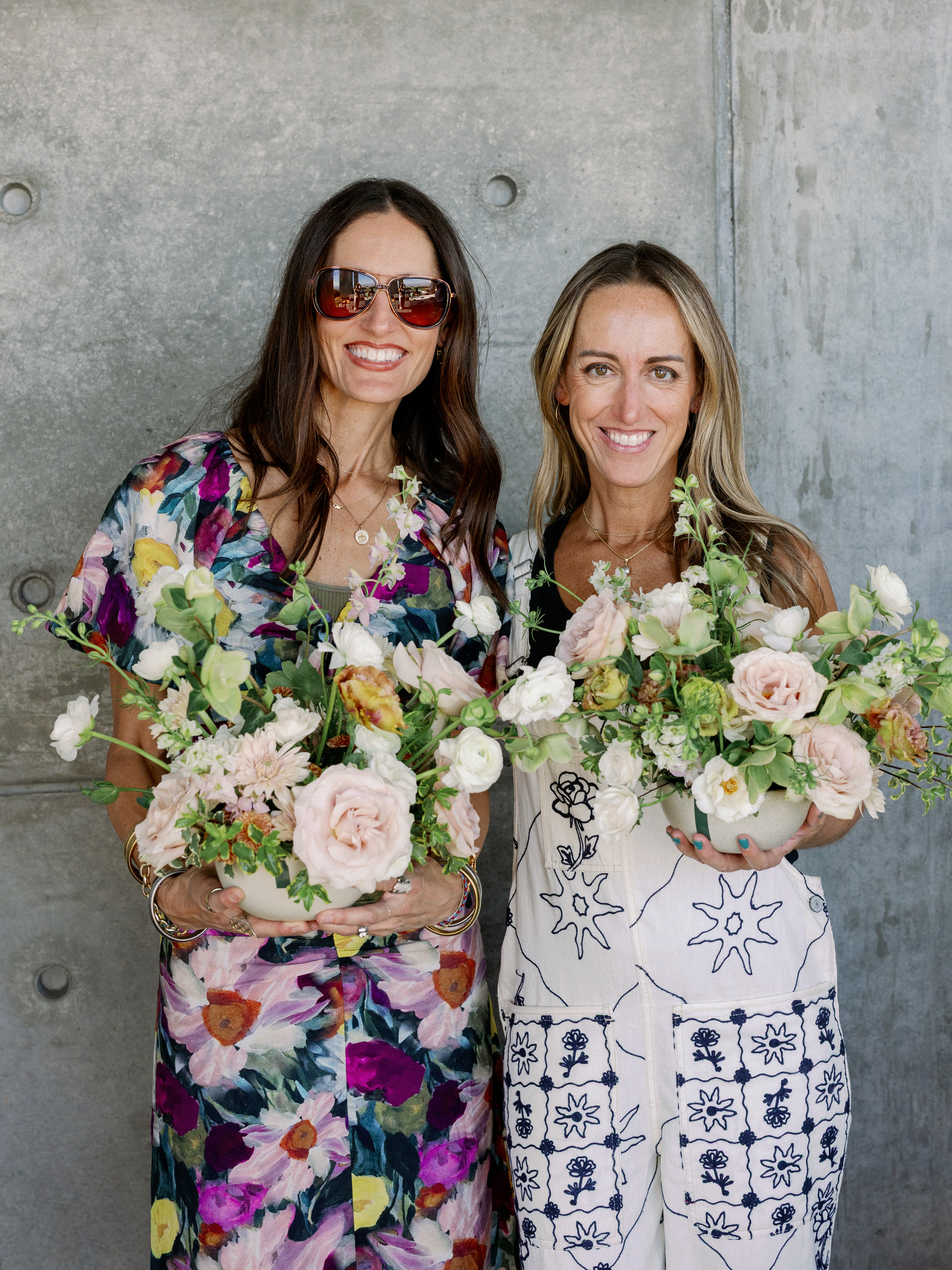 Jess and Jaryn holding flower arrangements
